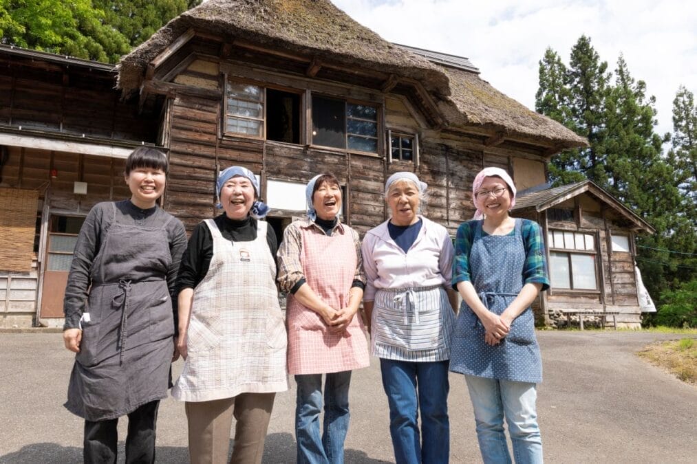 古民家の前に並ぶおばさん（うぶすなの家・大地の芸術祭）