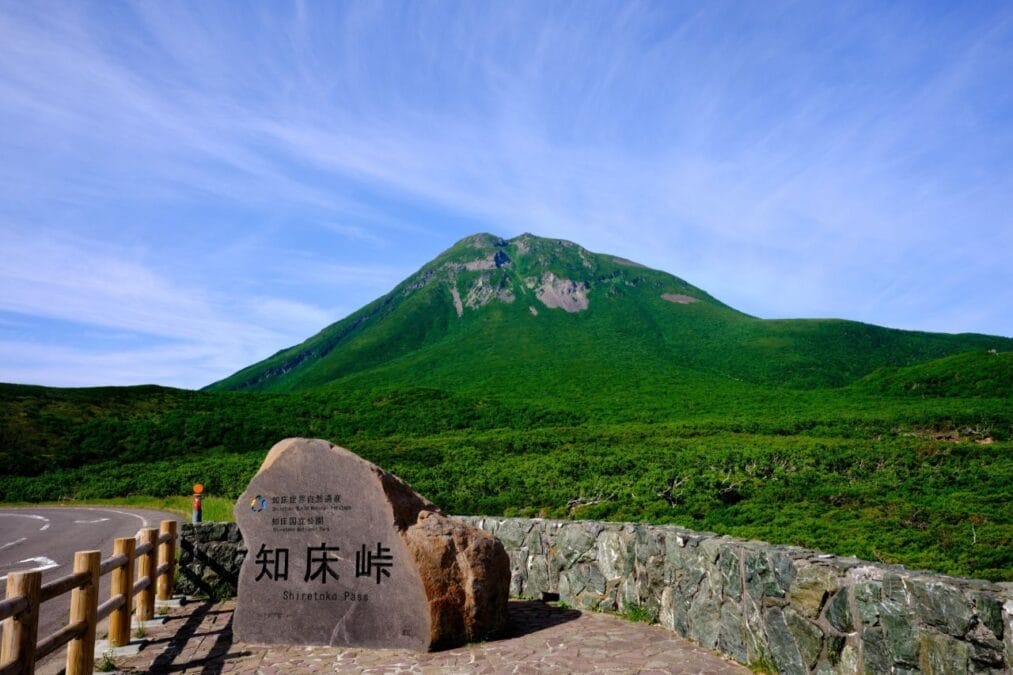 知床峠から望む羅臼岳の絶景。青空と緑の山々が広がる北海道・知床国立公園の展望スポット。
